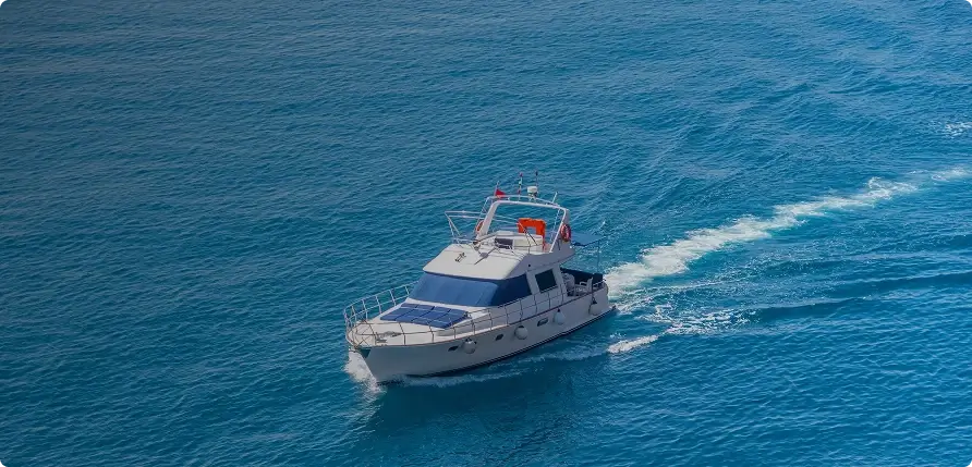 White boat with blue roof on a blue ocean
