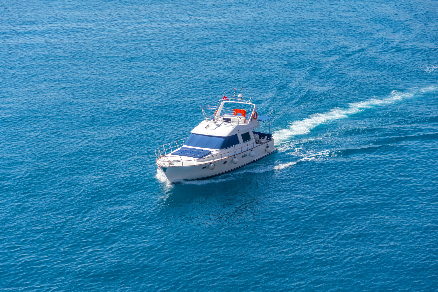 White yacht on a blue ocean with a clear sky